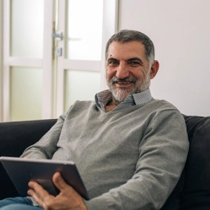 man-sitting-on-sofa-at-his-home-and-using